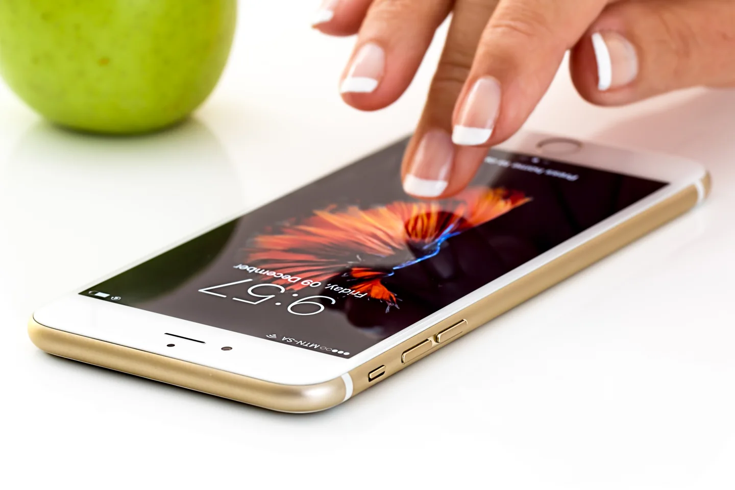 A hand using a smartphone on a desk