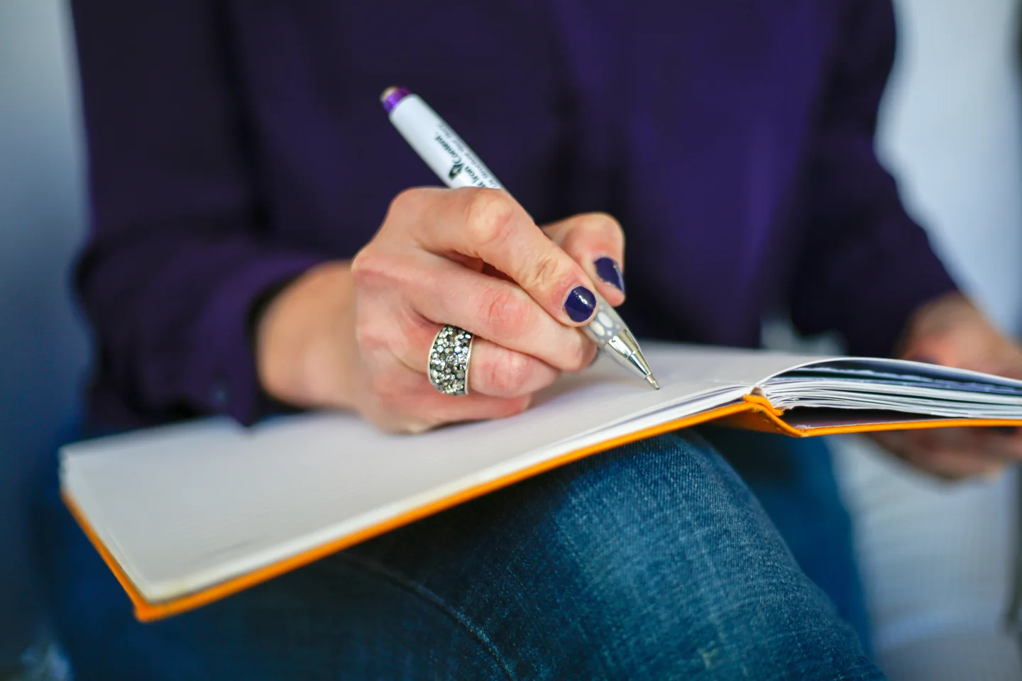 A hand writing notes in an open notebook