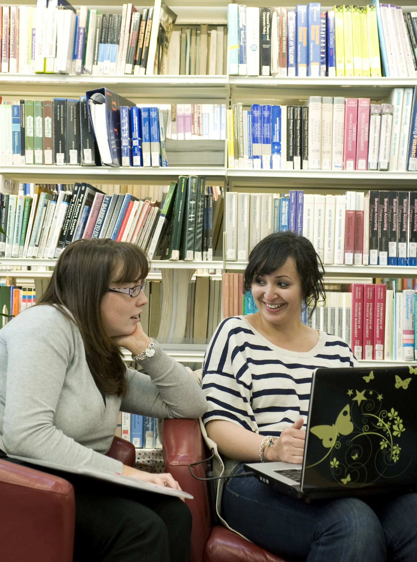 Two students working together with a laptop in Edinburgh University Library